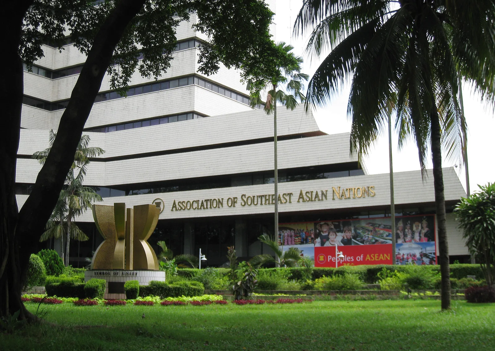 The ASEAN Secretariat building in Jakarta, with the ASEAN emblem and palms in front.